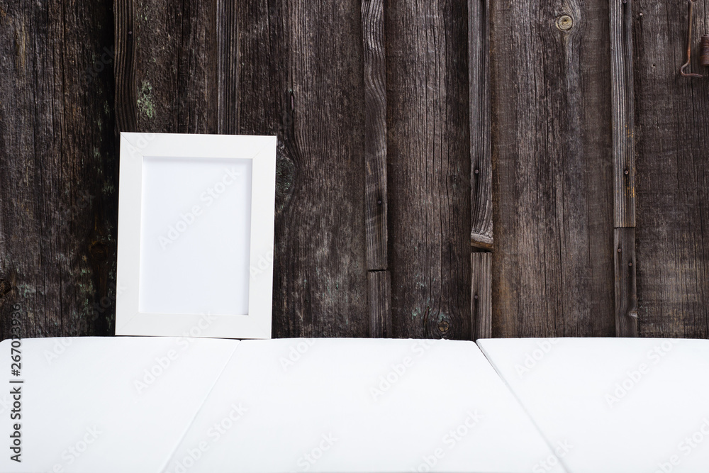 white picture frame, white table, old wooden wall - obrazy, fototapety, plakaty 