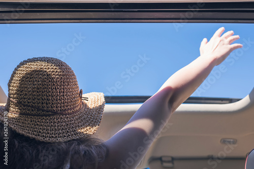 Foto girl driver traveling by car and holds her hand out from open hatch of a vehicle