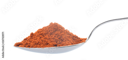 Red paprika powder in spoon closed up isolated on white