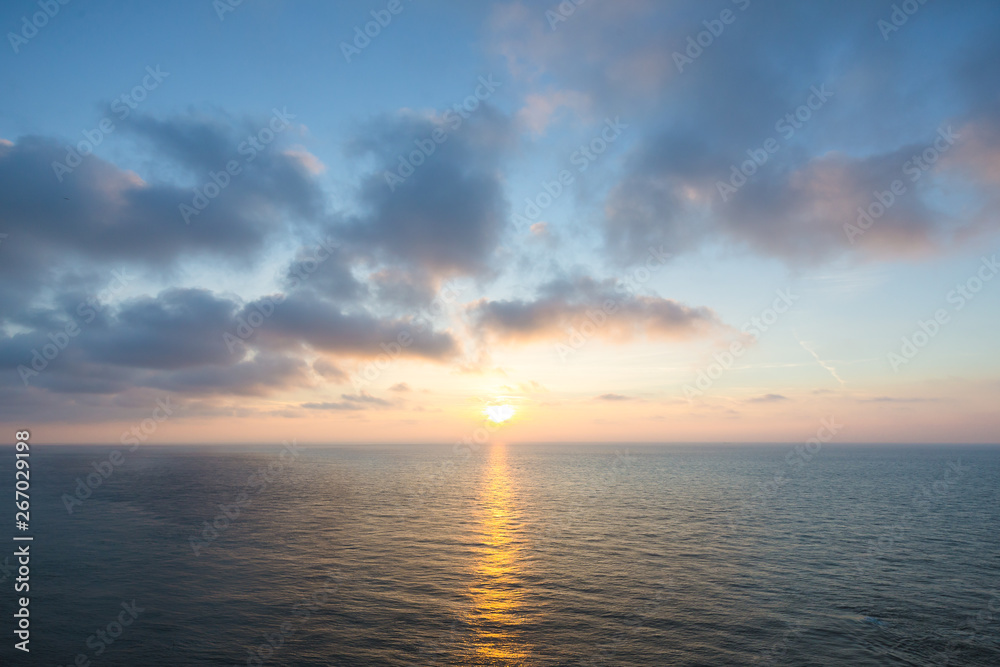 Beautiful sunset over sea , majestic clouds in the sky .