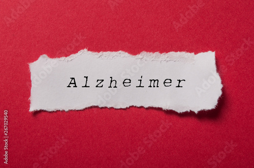 closeup of white torn paper on red paper background - Alzheimer