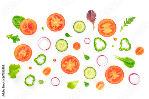 Fototapeta Naklejka Na Ścianę i Meble -  Fresh vegetable salad ingredients, shot from above on a white background. A flat lay composition with tomato, cucumber, peppers, onion slices and mezclun leaves