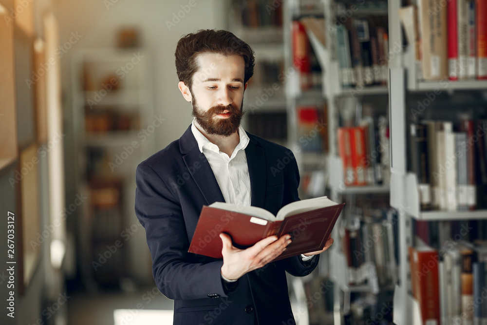 Man in a library. Guy in a black suit. Student with a books. Man in a library. Guy in a black suit. Student with a books.
