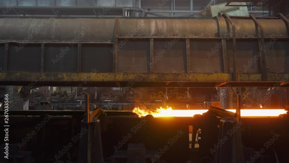 Steel mill, steel pipes production, red-hot pipe transported on production line, process of forming and cooling in heavy industry, rolled metal factory. Steel mill, steel pipes production, red-hot pipe transported on production line, process of forming and cooling in heavy industry, rolled metal factory.