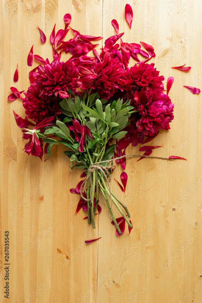 Peony background. Fuchsia, pink and white peonies on wooden table with place for text. Spring flower peony. Copy space. Toned image. Peony background. Fuchsia, pink and white peonies on wooden table with place for text. Spring flower peony. Copy space. Toned image.