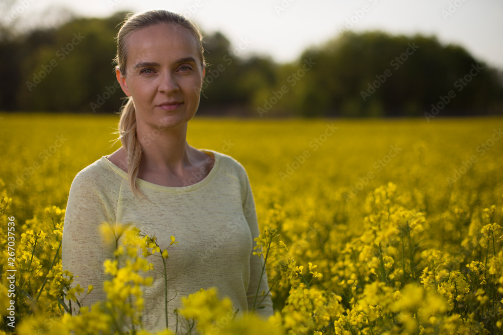 Happy woman on blooming rapeseed field in springin yellow blouse. Happy woman on blooming rapeseed field in springin yellow blouse.