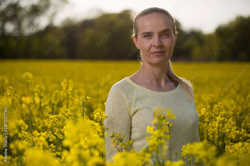 Happy woman on blooming rapeseed field in springin yellow blouse. Happy woman on blooming rapeseed field in springin yellow blouse.