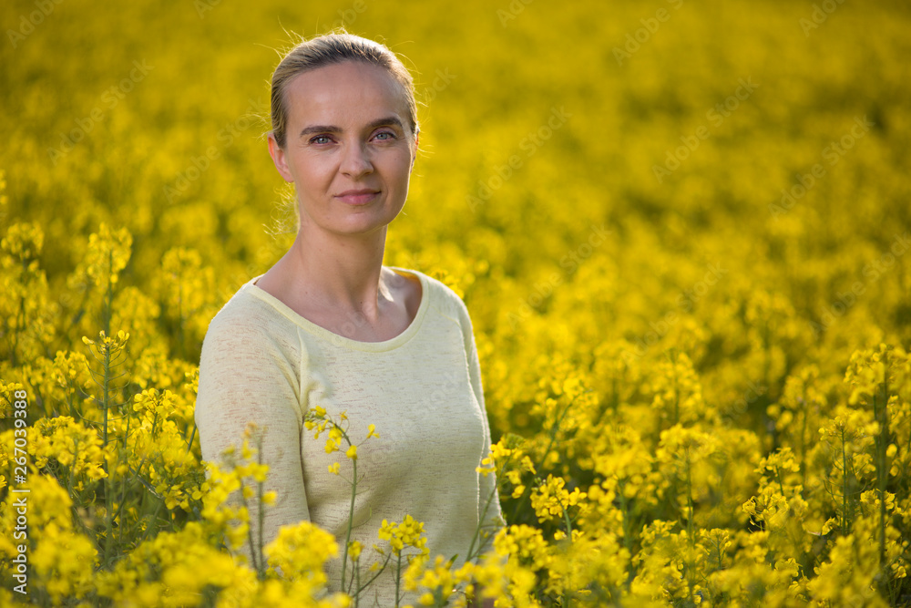 Happy woman on blooming rapeseed field in springin yellow blouse. Happy woman on blooming rapeseed field in springin yellow blouse.