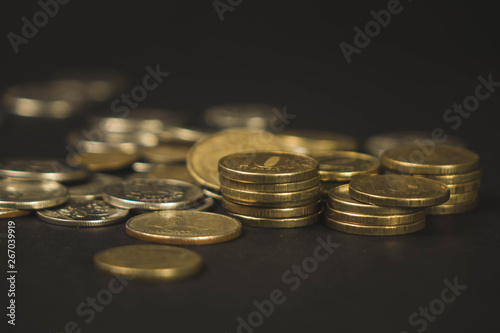 many coins scattered in a chaotic manner on a black background.