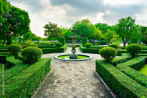 Sleepiness fountain in middle of crushed rock road are luxury garden in Bangkok, Thailand. This line of crushed rock road go straight to fountain concept,  forest and blue sky in a background.