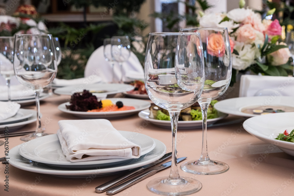 Served for banquet restaurant table with dishes, snack, cutlery, wine and water glasses, european food, selective focus