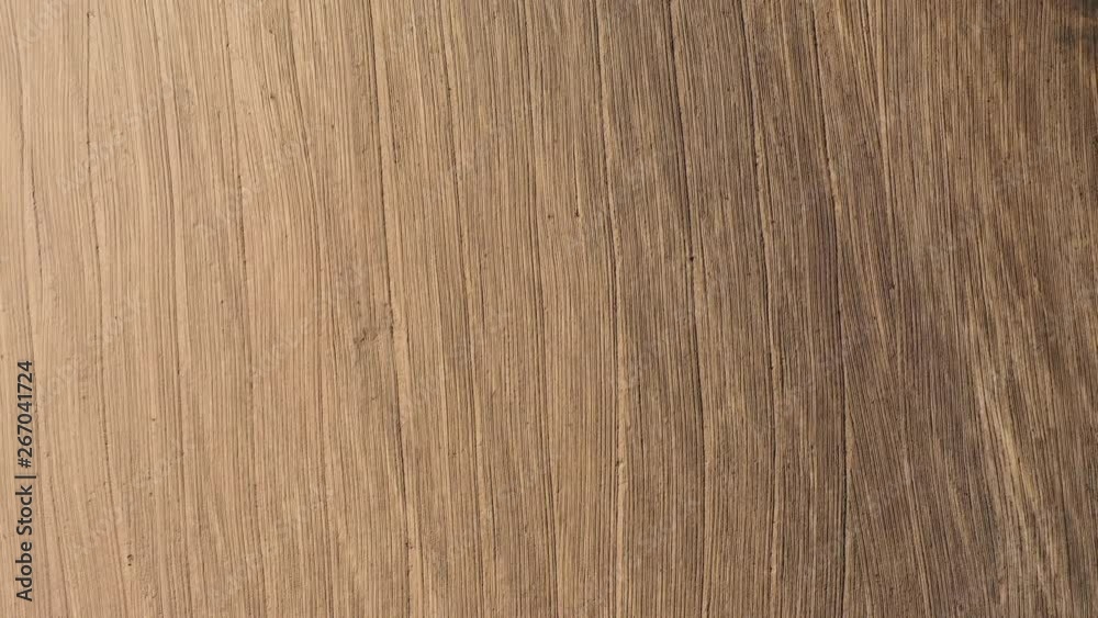 Ascending aerial view over a ploughed field on farmland, featuring a textured row of vertical lines Ascending aerial view over a ploughed field on farmland, featuring a textured row of vertical lines