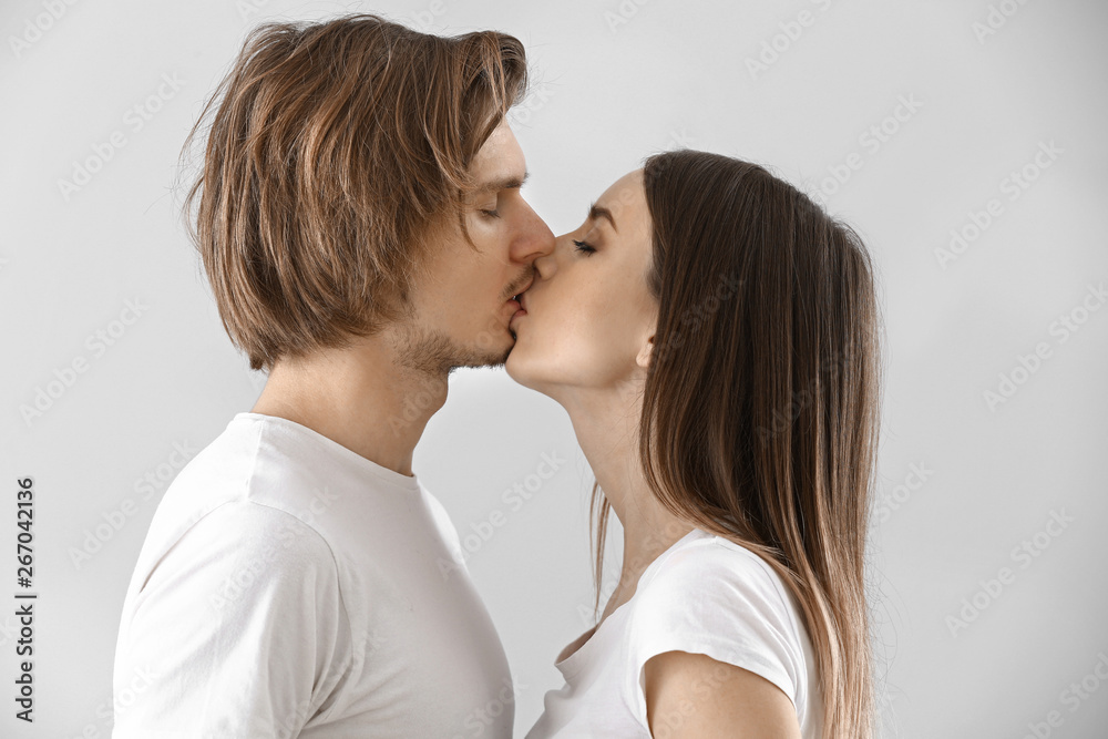 Kissing young couple on light background Kissing young couple on light background
