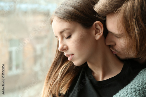 Young couple near window at home