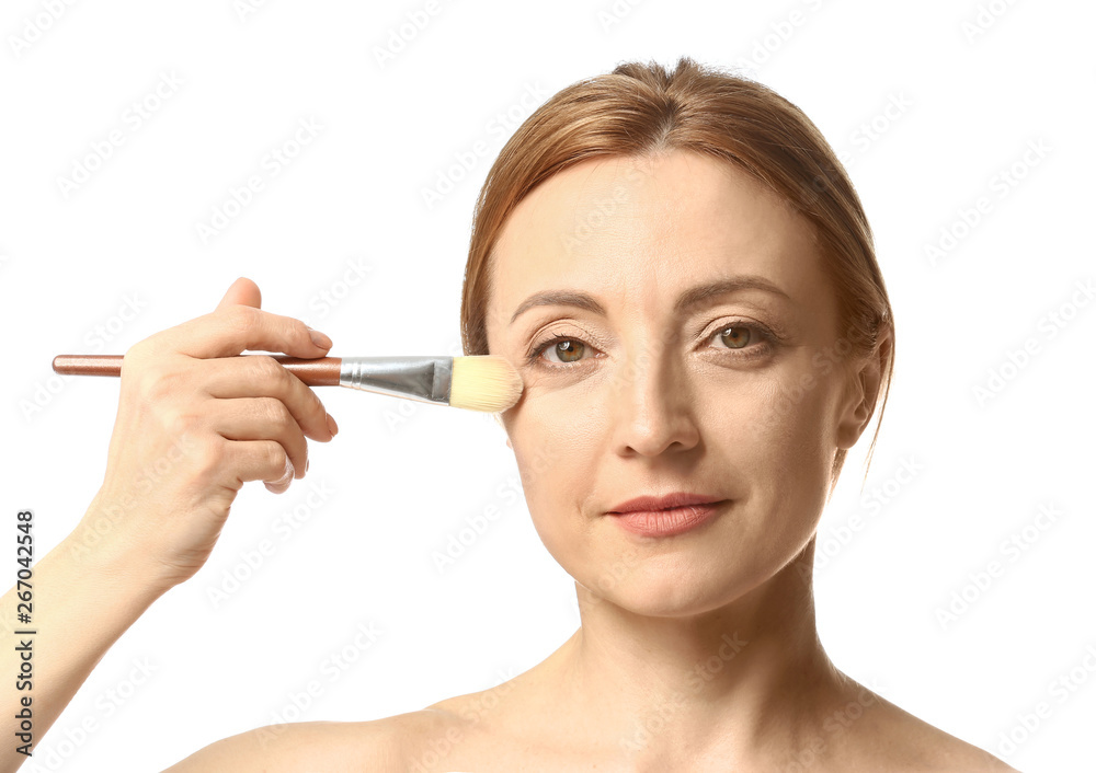 Mature woman with makeup brush on white background Mature woman with makeup brush on white background