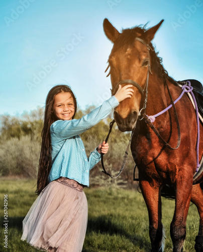 Beautiful girl with horse on the grass. Friendship concept.