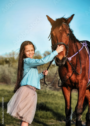 Beautiful girl with horse on the grass. Friendship concept.