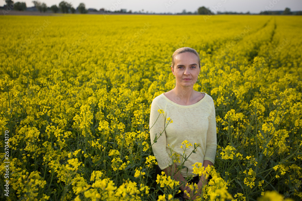 Happy woman on blooming rapeseed field in springin yellow blouse. Happy woman on blooming rapeseed field in springin yellow blouse.