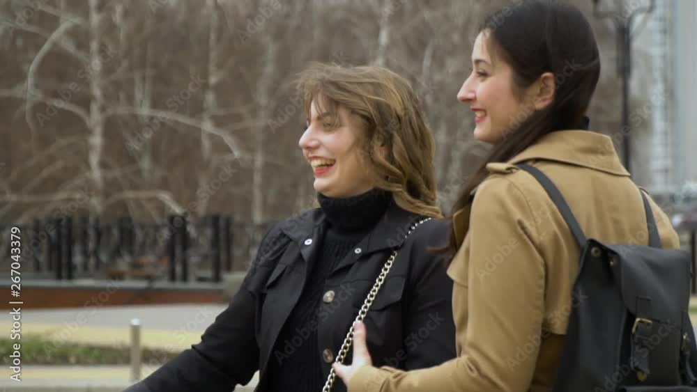 Girlish friendship. Three young beautiful girls met and chat in the street. They are happy. Girls are happy to meet. They hug. Slow motion. Girlish friendship. Three young beautiful girls met and chat in the street. They are happy. Girls are happy to meet. They hug. Slow motion.
