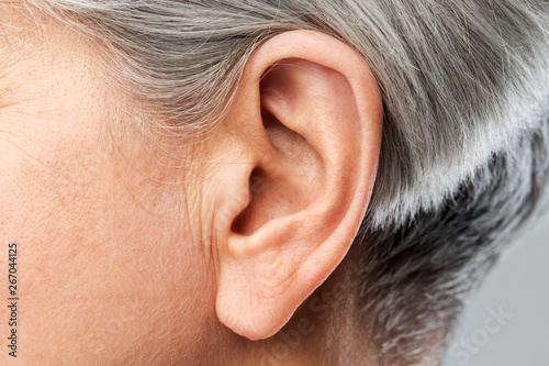 Fotobehang hearing, body part and old age concept - close up of senior woman ear