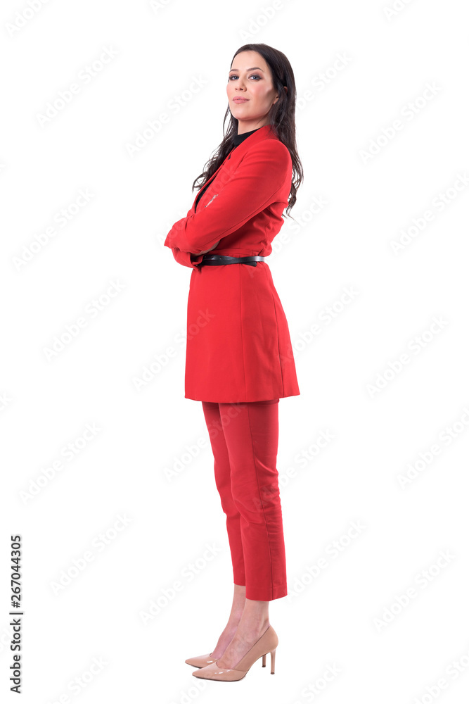 Confident successful female business director in red suit standing with crossed arms. Full body isolated on white background.