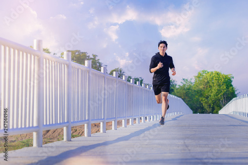 Man running sprinting on road. Fit female fitness runner during outdoor workout