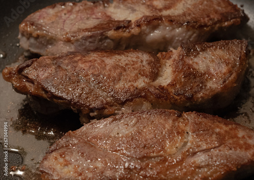 Sizzling Steaks in a Frying Pan