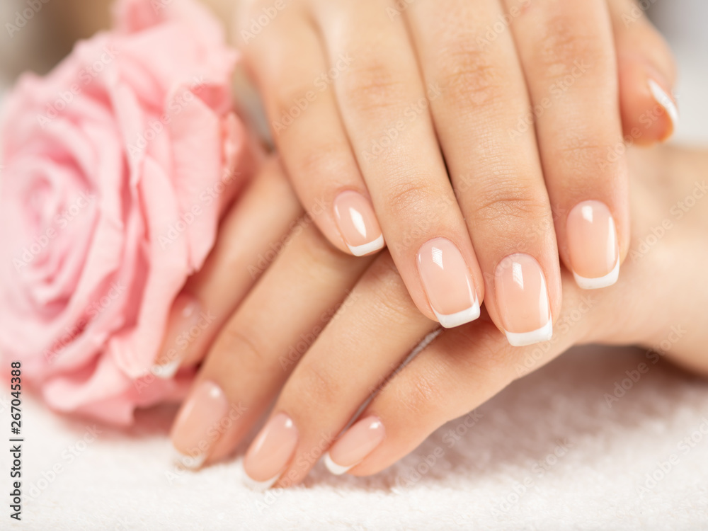 Woman gets manicure procedure in a spa salon. Beautiful female hands.