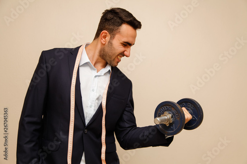 Muscular Office worker  holding a dumbbell in his hand sport and oddice conceptions  photo