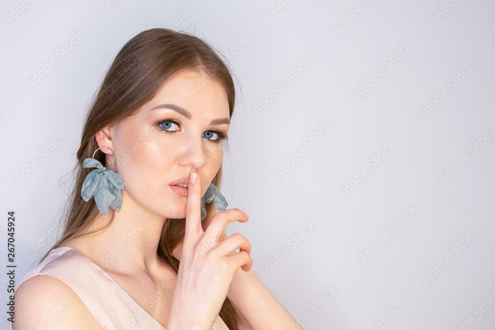 Attractive young girl touching her lips. Photo of blonde girl with perfect skin on grey background. Beauty Skin care concept Makeup Limited depth of field Attractive young girl touching her lips. Photo of blonde girl with perfect skin on grey background. Beauty Skin care concept Makeup Limited depth of field