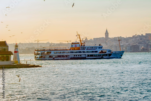Muslim architecture and water transport in Turkey - Beautiful View touristic landmarks from sea voyage on Bosphorus. Cityscape of Istanbul at sunset - old mosque and turkish steamboats, view on Golden