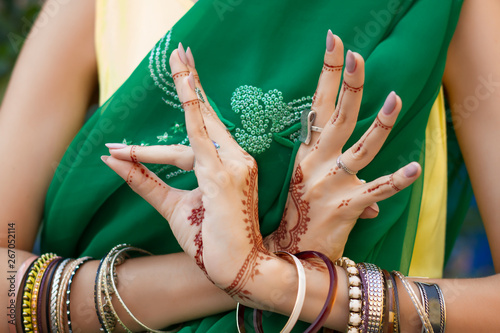 Beautiful woman in traditional Muslim Indian wedding green sari dress costume with henna tattoo jewelry bracelets do hands nritta odissi Samyuta Hasta Mudras dance Movement bird Concept background photo