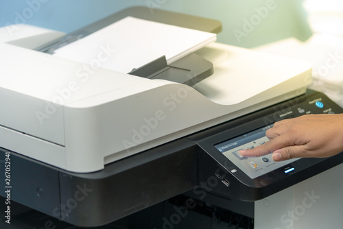 Woman's hand touching the screen to copy documents from photocopiers or multifunction machine.