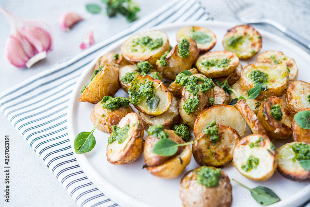 Baked potatoes in rustic style with green pesto sauce