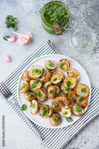 Baked potatoes in rustic style with green pesto sauce