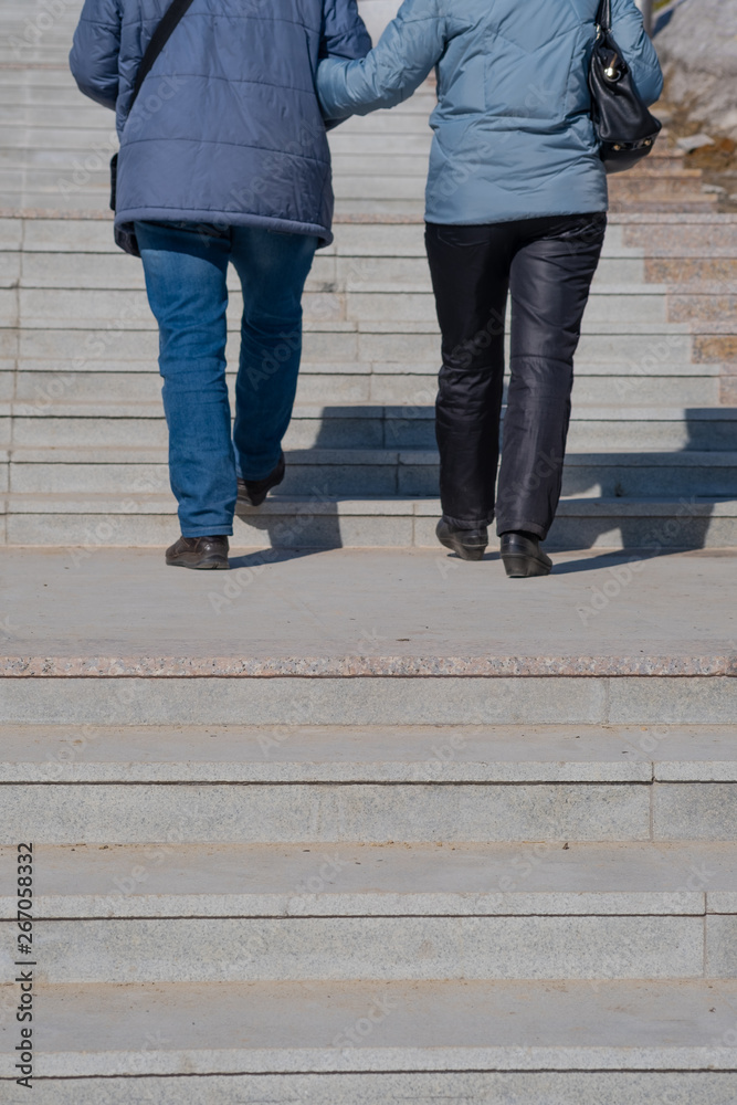 A man and a woman go up the stairs.