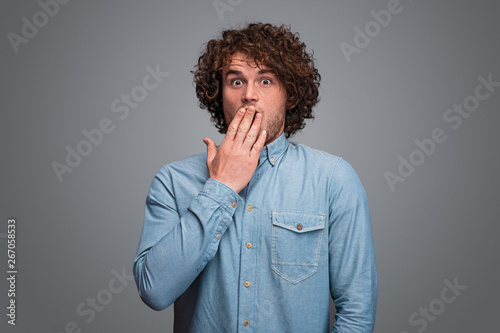 Shocked young male covering mouth