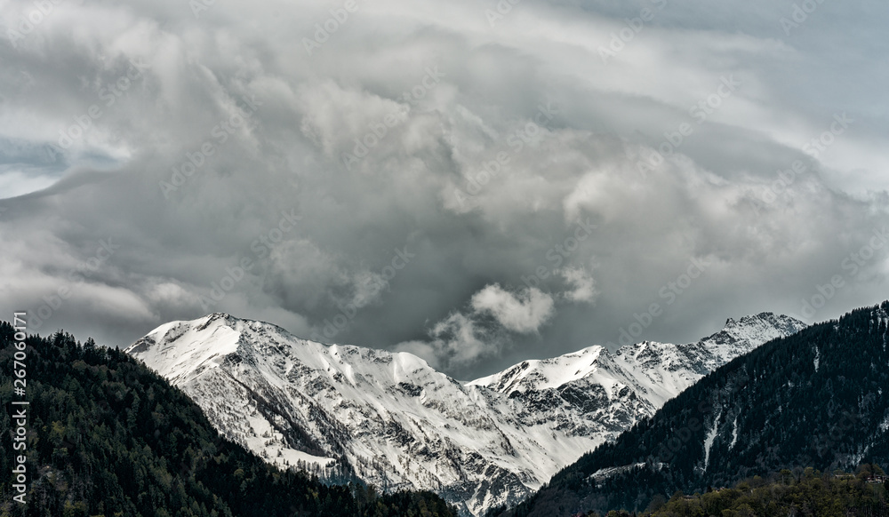 panorama mountain landscape with snowcapped peaks and expressive cloudscape