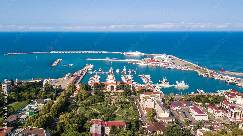 Aerial photography. Panoramic view of the sea port of Sochi on a clear day. Blue sky. Yachts and boats are berthed. Attraction of the resort city.