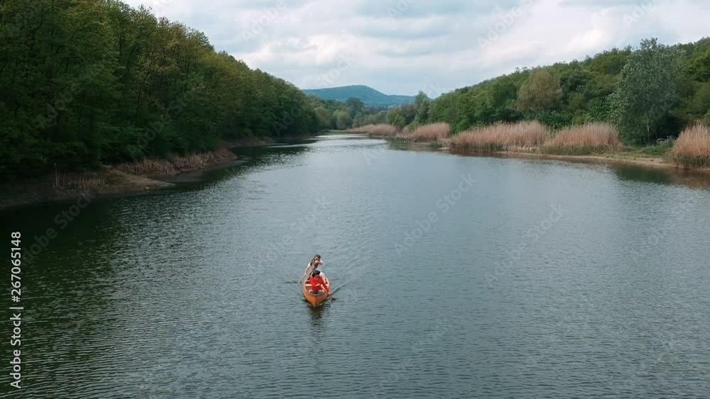 Aerial view of couple paddling in a wooden canoe Aerial view of couple paddling in a wooden canoe
