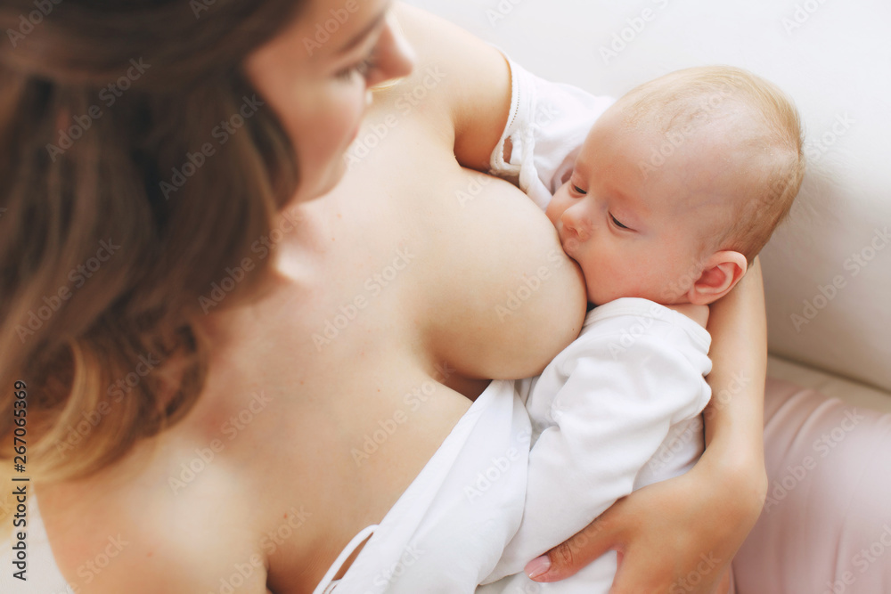 close up of mother breast feeding her newborn baby girl at home close up of mother breast feeding her newborn baby girl at home