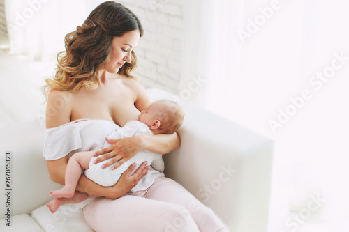 close up of mother breast feeding her newborn baby girl at home