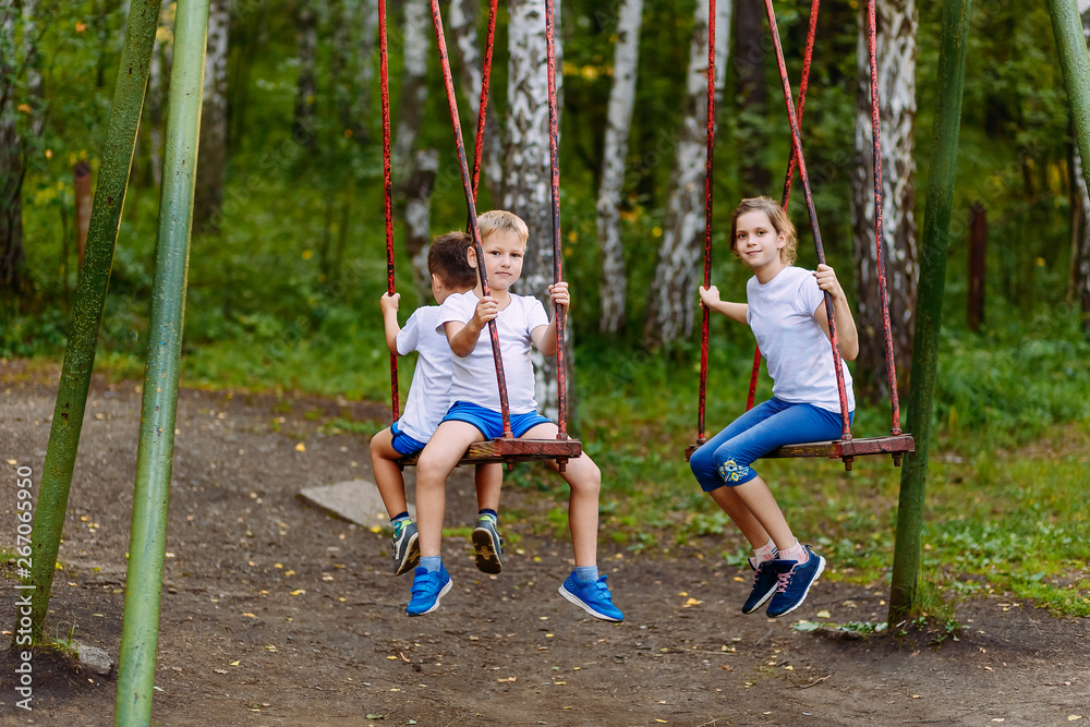 children play on the swings in the summer children play on the swings in the summer