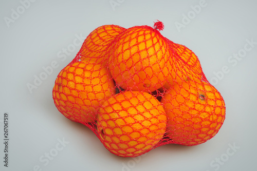 Fresh oranges in mesh isolated on the gray background