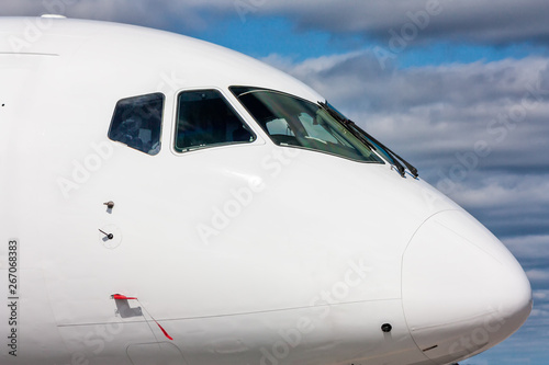 Close view of the cockpit of a white passenger plane outside