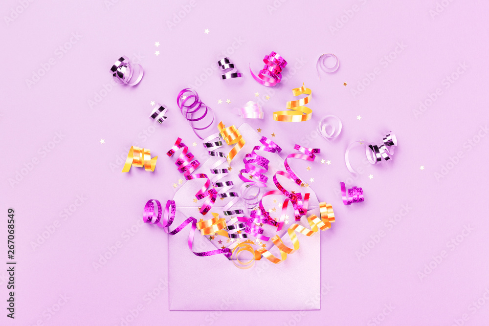Birthday party explosion concept. Envelope with party streamers and confetti on lilac background. Invitation and greeting card, flat lay.