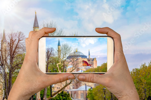 Tourist taking a picture in front of  The  Hagia Sophia Museumat spring, Istanbul, Turkey. Travel concept