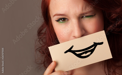 Person with smile card in front of his mouth 