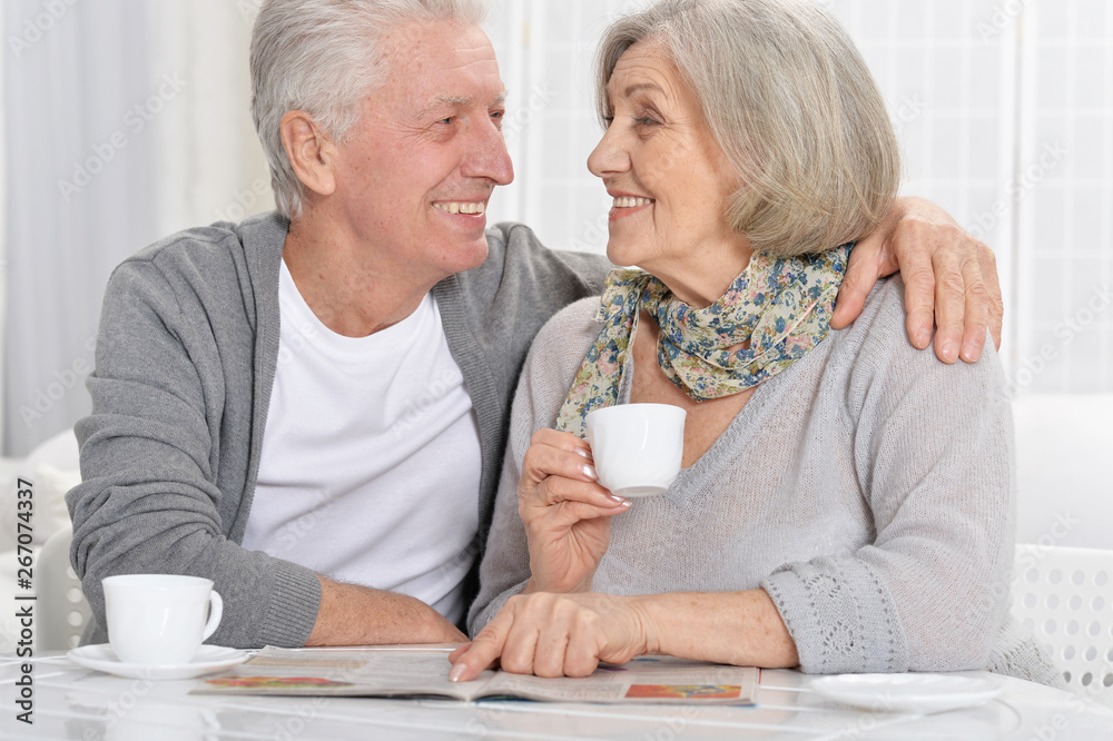 Portrait of mature couple with magazine drinking tea 