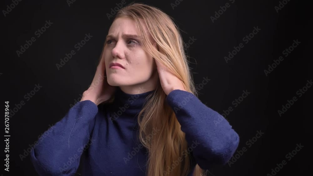 Portrait of miserable young blonde model with fuzz hair suffering from terrible migraine on black background. Portrait of miserable young blonde model with fuzz hair suffering from terrible migraine on black background.